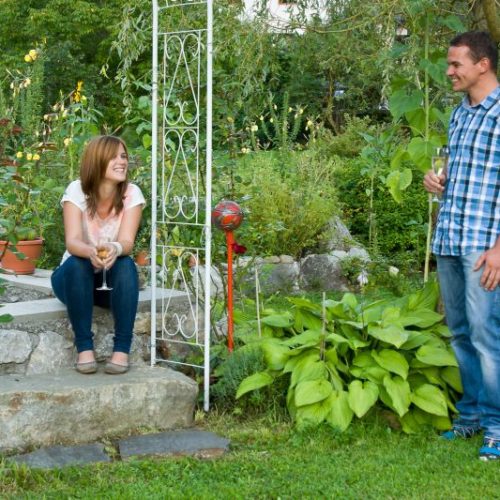Eine Frau und ein Mann unterhalten sich im hauseigenen Garten